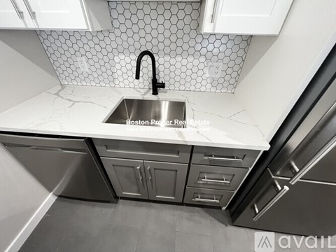 A modern kitchen with a stainless steel sink and cabinets.