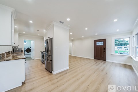 A kitchen with white cabinets and a marble countertop.
