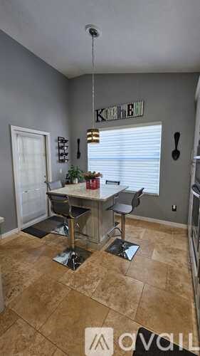 A kitchen with a table and chairs in the middle of the room.