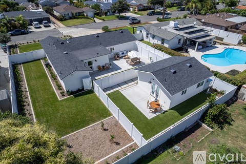 A large white house with a pool in the backyard.