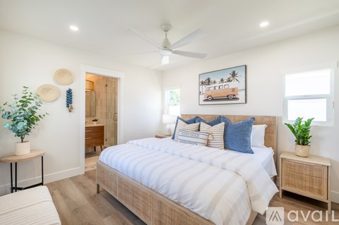 A bedroom with a large bed and a ceiling fan.