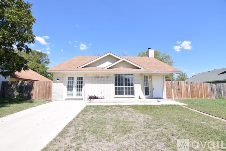 A house with a brown roof and a white exterior is for sale.