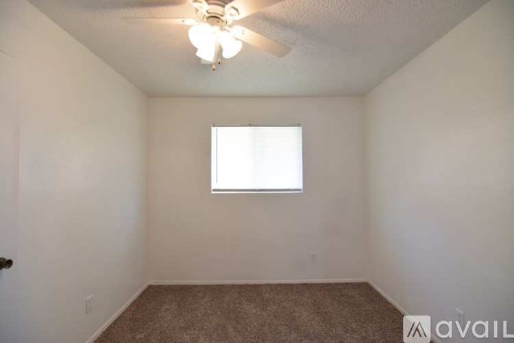 A room with a ceiling fan and a window.