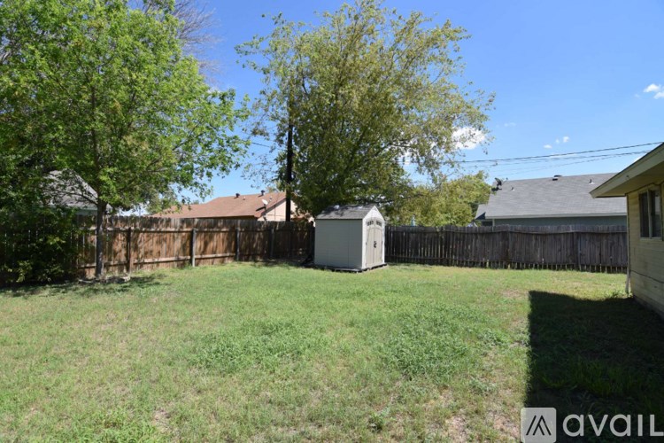 A backyard with a fence and a shed.