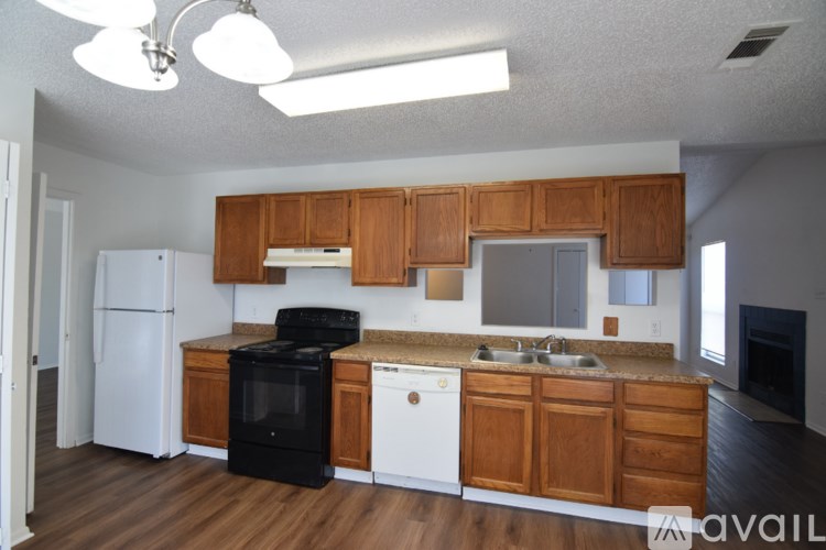 A kitchen with wooden cabinets and black appliances.