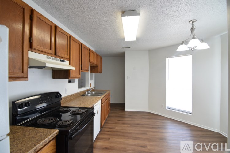 A kitchen with wooden cabinets and a black stove top oven.