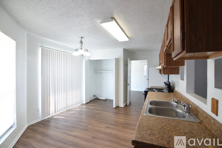 A kitchen with a sink and wooden cabinets.