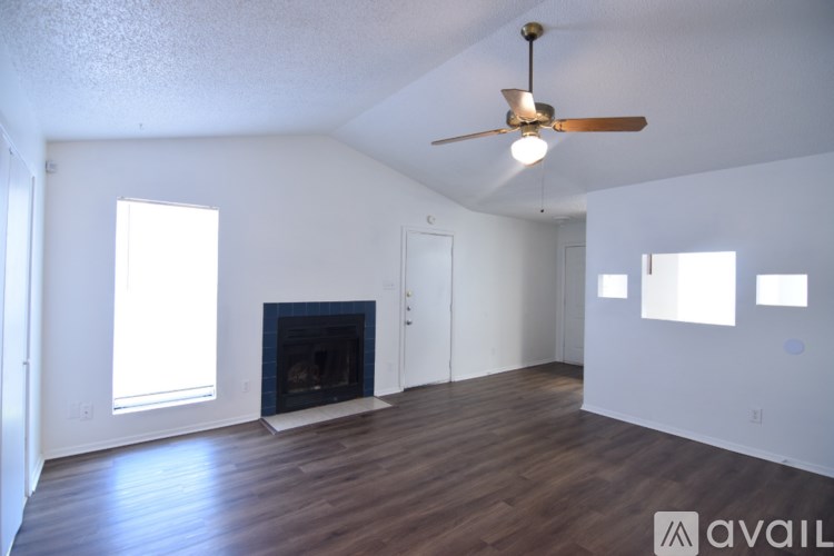 A room with a fireplace and a ceiling fan.
