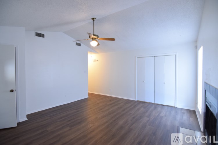 A room with a ceiling fan and wooden flooring.
