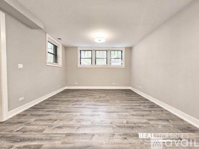 A spacious room with a window and a wooden floor.