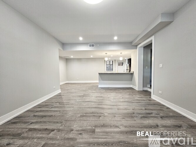 A spacious room with a grey carpet and white walls.