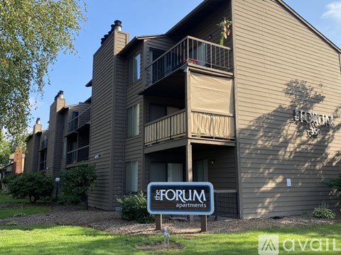 A building with a sign that says "FORUM Apartments".
