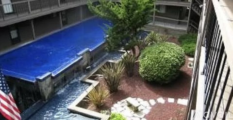 A small pool with a waterfall in the middle of a courtyard.