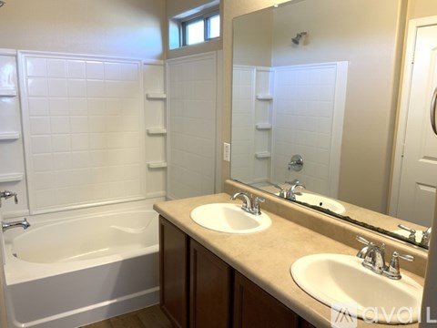 A white tiled bathroom with a double sink vanity.