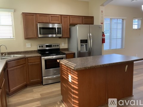 A kitchen with wooden cabinets and a granite counter.