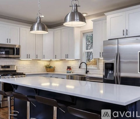 A modern kitchen with white cabinets and a large island.