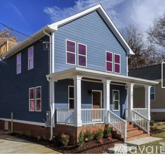 A blue house with a porch and a white railing.