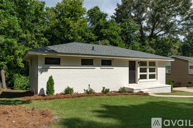 A white house with a grey roof and a brown door.