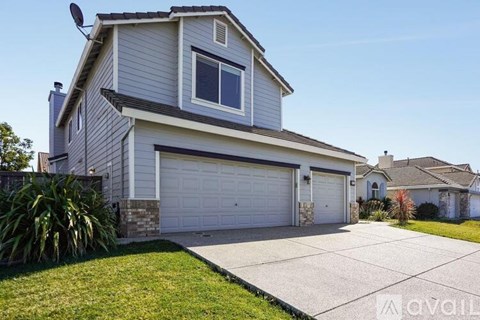 A two-story house with a garage and a driveway.