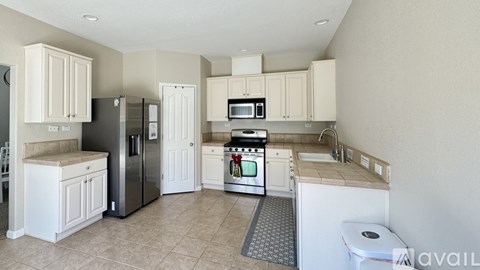 A kitchen with white cabinets and appliances.