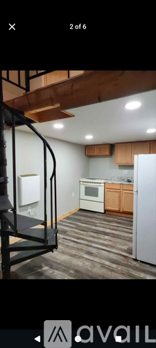 A kitchen with white appliances and wooden floors.