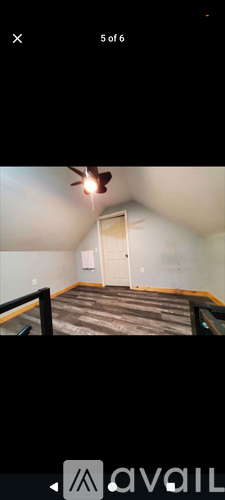 A room with a ceiling fan and a door.