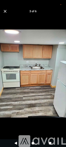 A kitchen with wooden cabinets and a white fridge.
