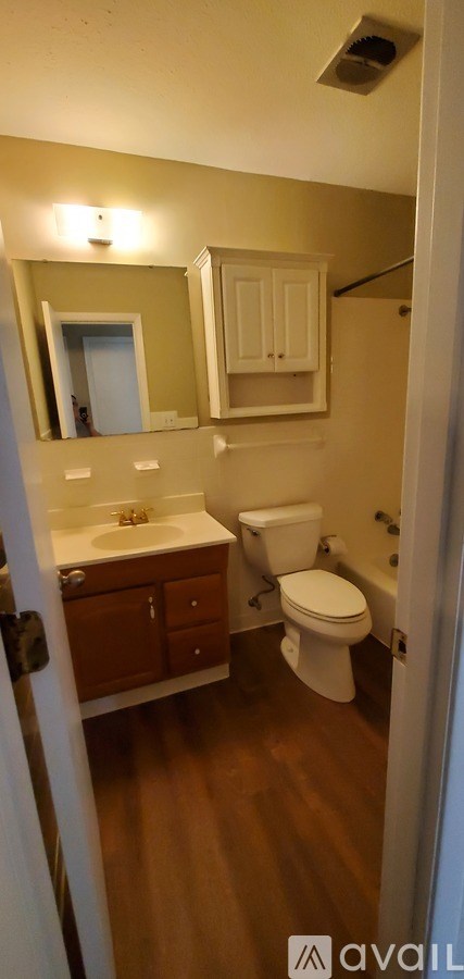 A bathroom with a toilet, sink, and medicine cabinet.