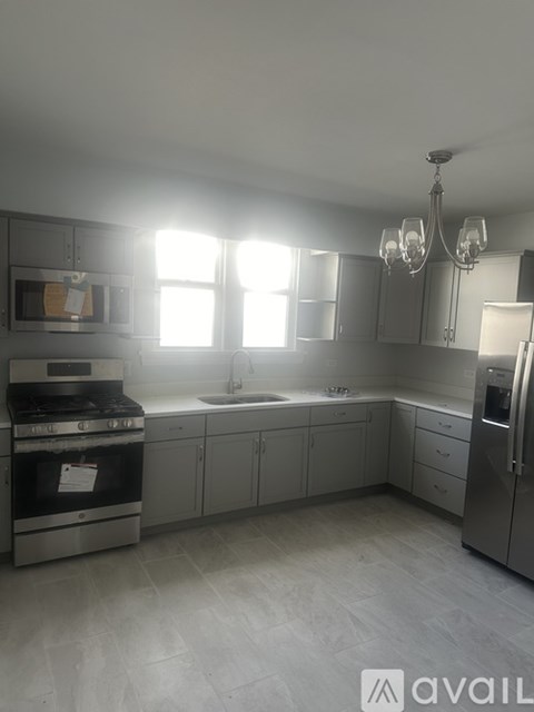A kitchen with a stove, sink, and refrigerator.