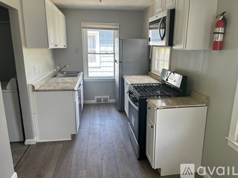 A kitchen with white cabinets and a black stove top oven.
