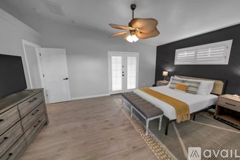 A bedroom with a bed, dresser, and ceiling fan.