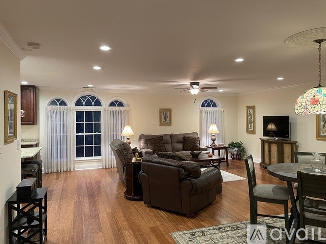 A living room with a brown couch and a wooden floor.