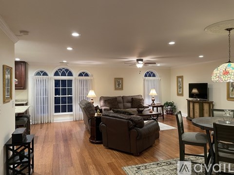 A living room with a brown couch and a wooden floor.