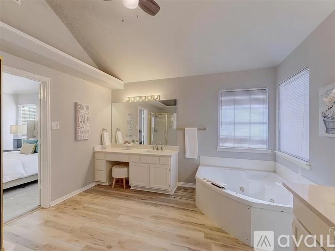A bathroom with a tub, sink, and mirror.