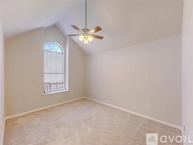 A room with a ceiling fan and a window with blinds.