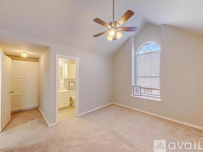 A room with a ceiling fan and a window with blinds.