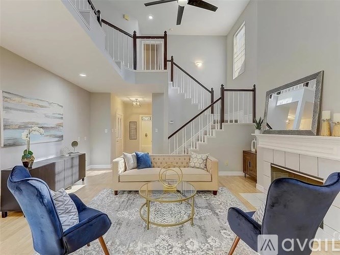 A living room with a staircase and a fireplace.