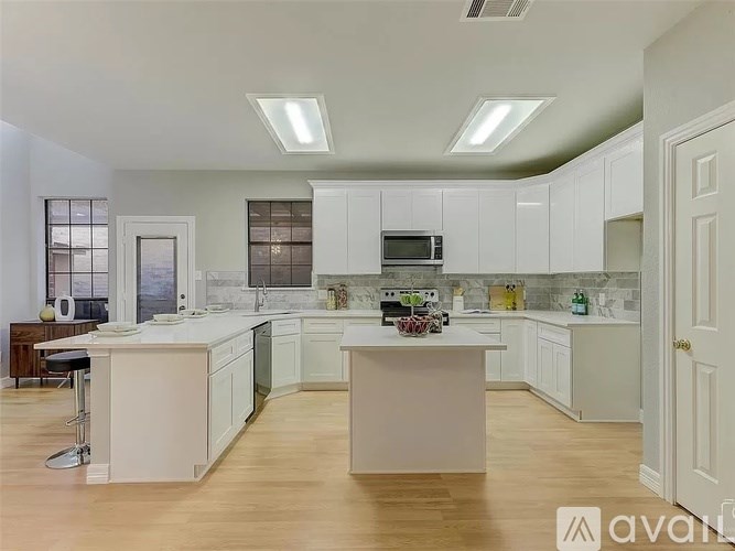A kitchen with white cabinets and a central island.
