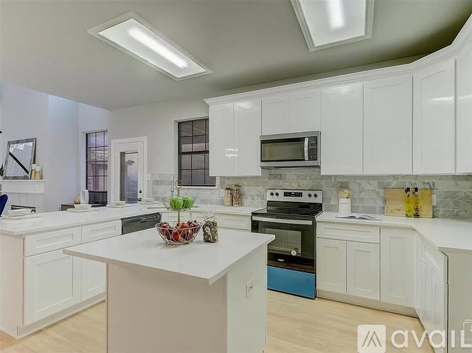A modern kitchen with white cabinets and a central island.