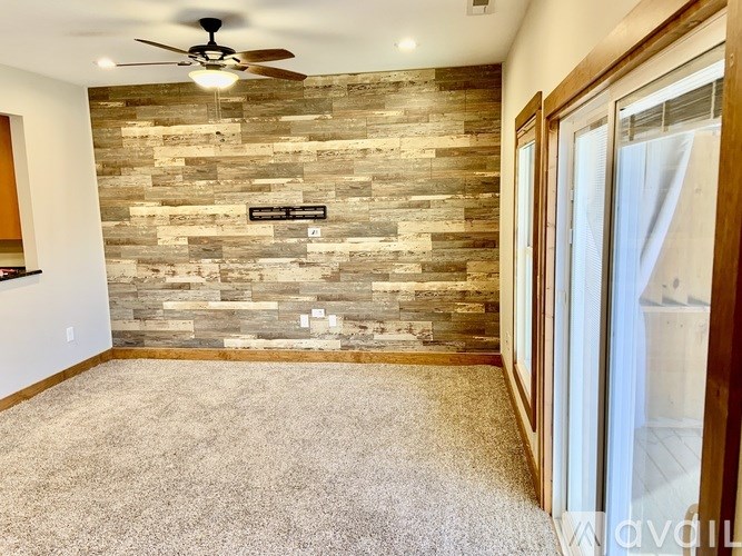 A room with a stone wall and a ceiling fan.