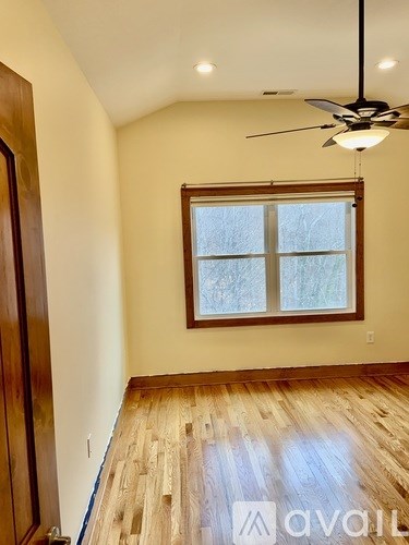 A room with wooden floors and a ceiling fan.