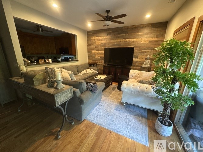 A living room with a wooden floor and a brick wall.