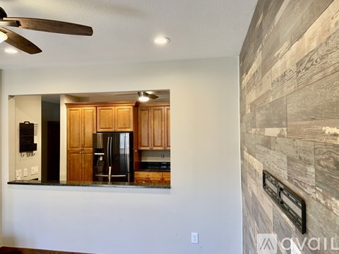 A kitchen with wooden cabinets and a black fridge.