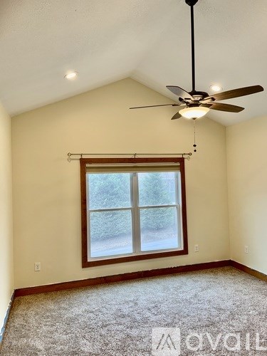 A room with a ceiling fan and a window.