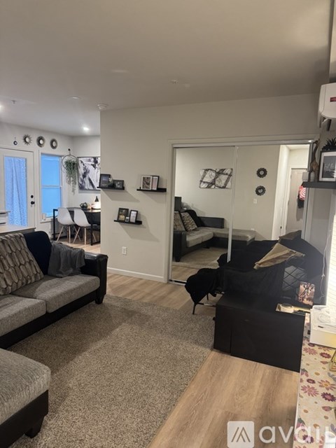 A living room with a grey couch and a black ottoman.