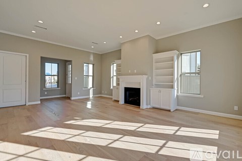 A spacious living room with a fireplace and a large rug on the floor.