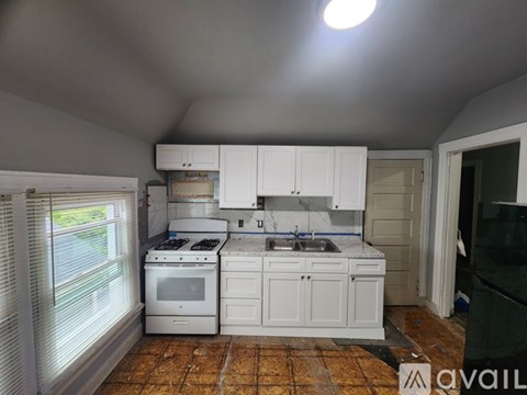 A kitchen with white cabinets and a tiled floor.
