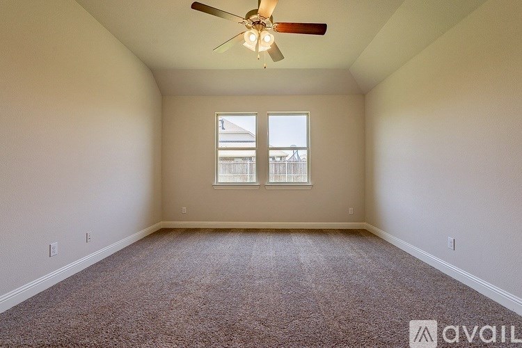 A room with a ceiling fan and carpeted floor.