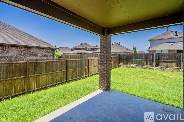 A covered backyard area with a blue path and a wooden fence.