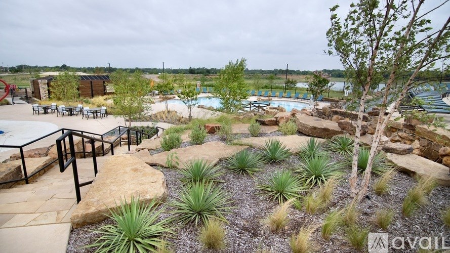 A rocky outdoor area with a pool and trees.